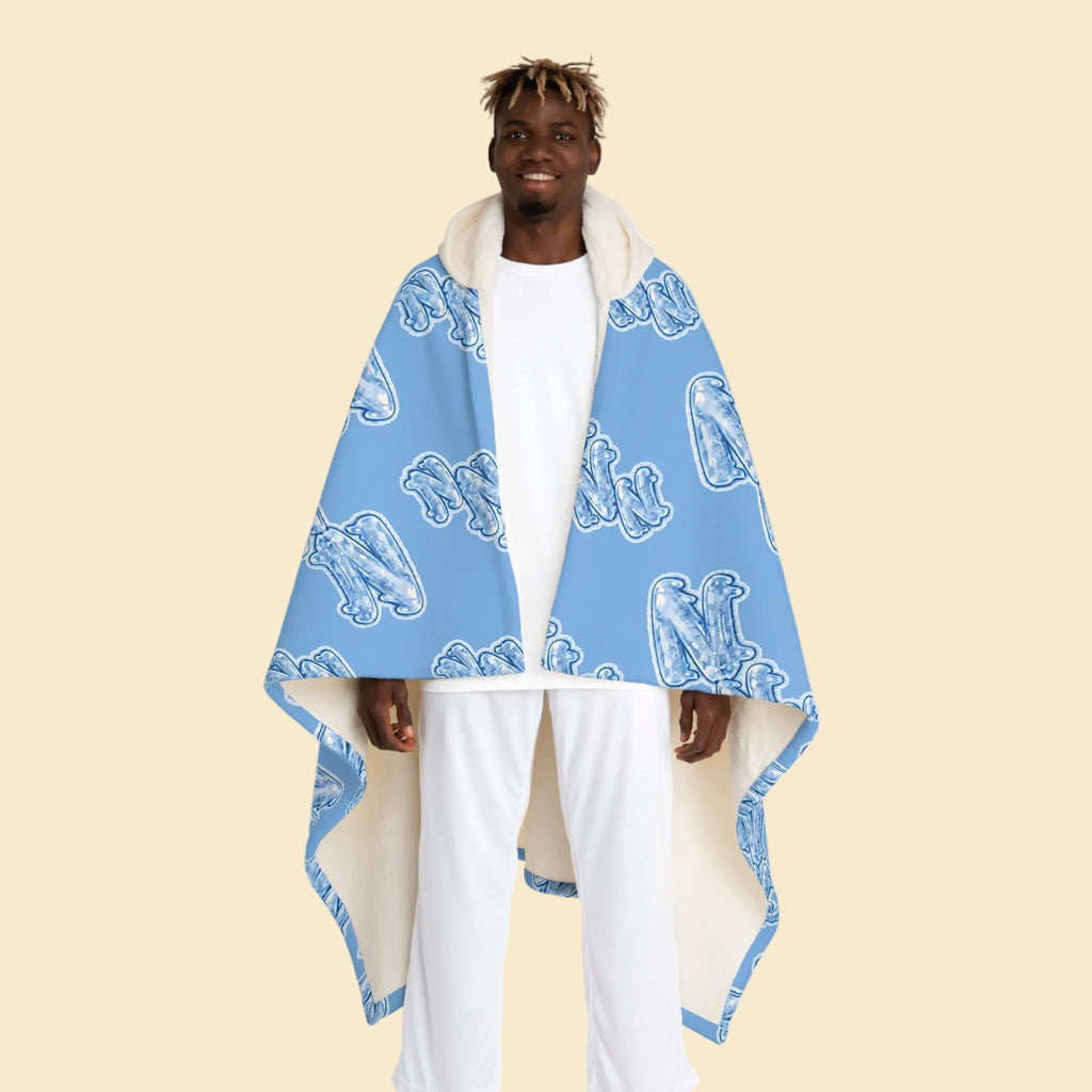 Model wearing the Cozy Blue Hooded Sherpa Blanket featuring the signature Frozen ZZZ's pattern and white sherpa-lined hood.