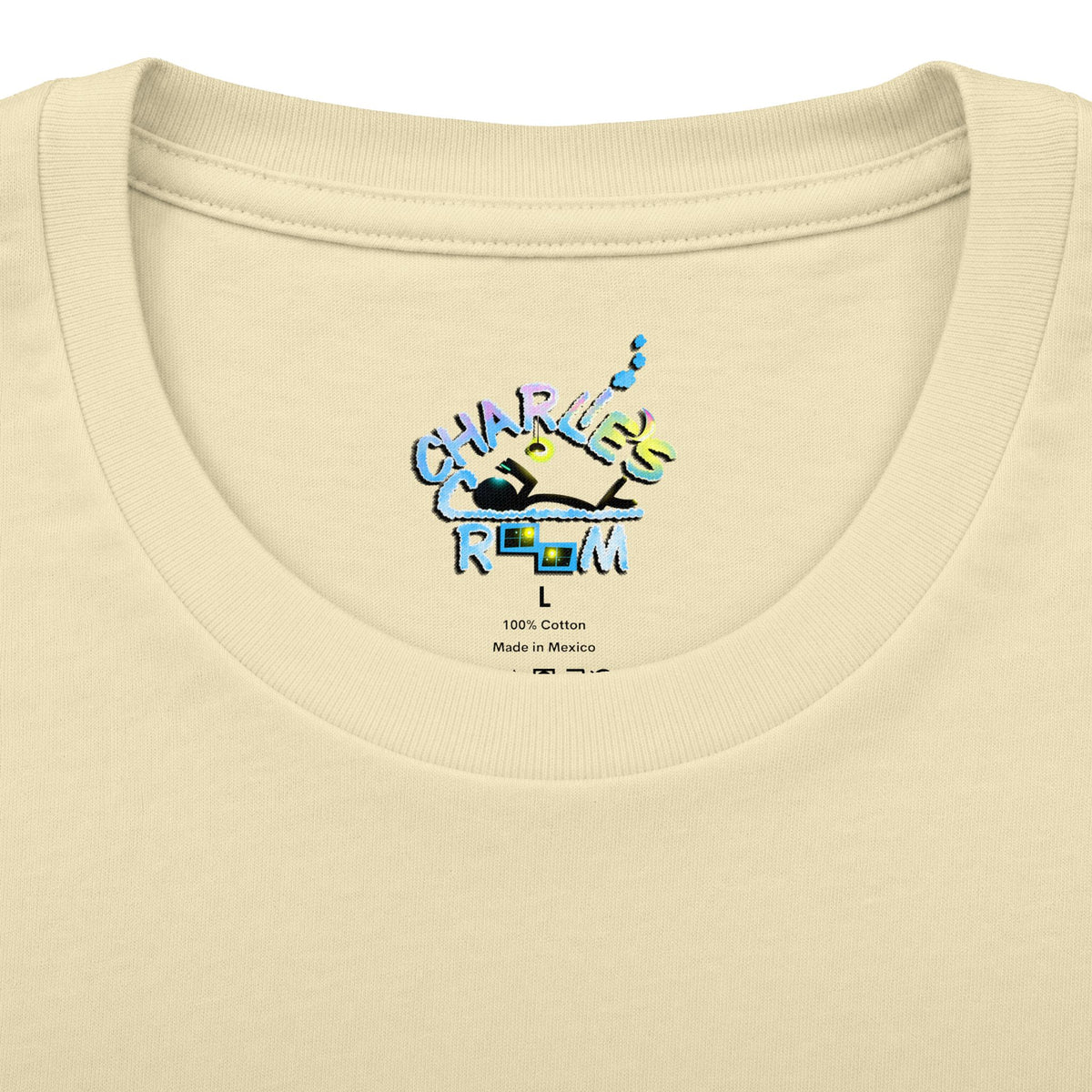 Close-up of the inside collar neck label of a cream-colored t-shirt, featuring the Charlie's Cozy Room brand logo with the blue and pink marquee-style text and a size indicator.