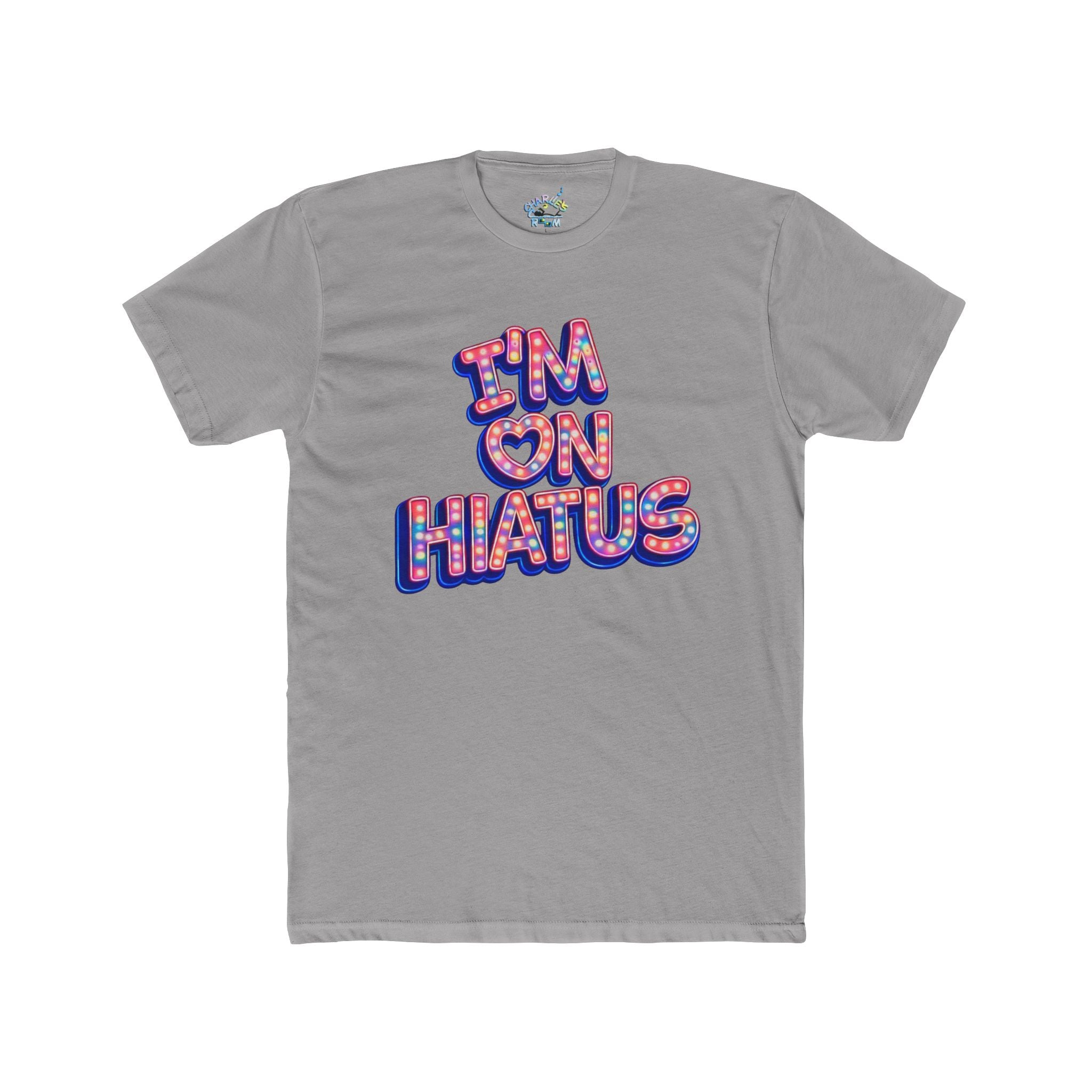 A gray short-sleeve crewneck t-shirt featuring a graphic text print that reads 'I'M ON HIATUS' in a 3D block font filled with a red, white, pink, and blue pattern and outlined in blue.
