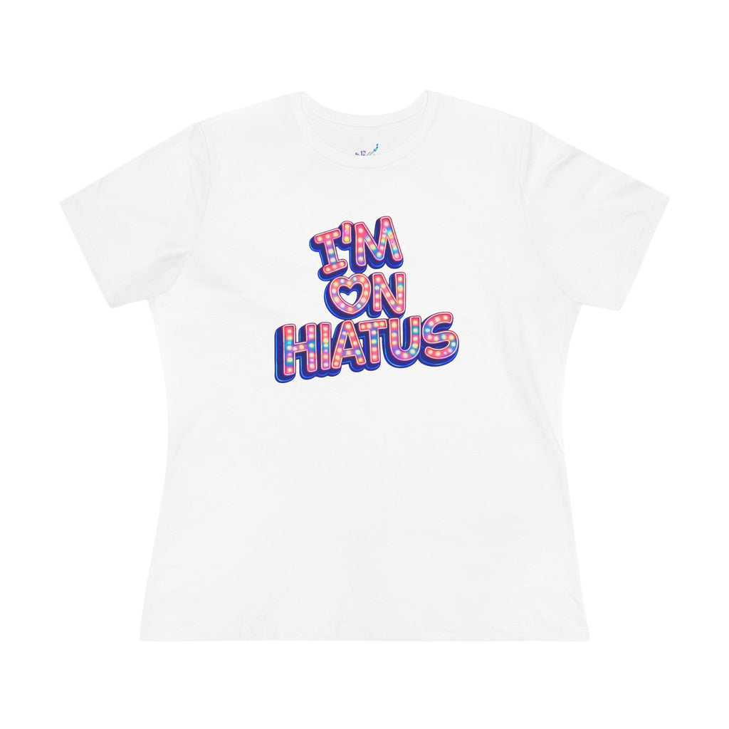 A white short-sleeve crewneck t-shirt featuring a colorful graphic on the chest that reads 'I'M ON HIATUS' in a bubbly, patterned font with red, pink, and blue outlines.