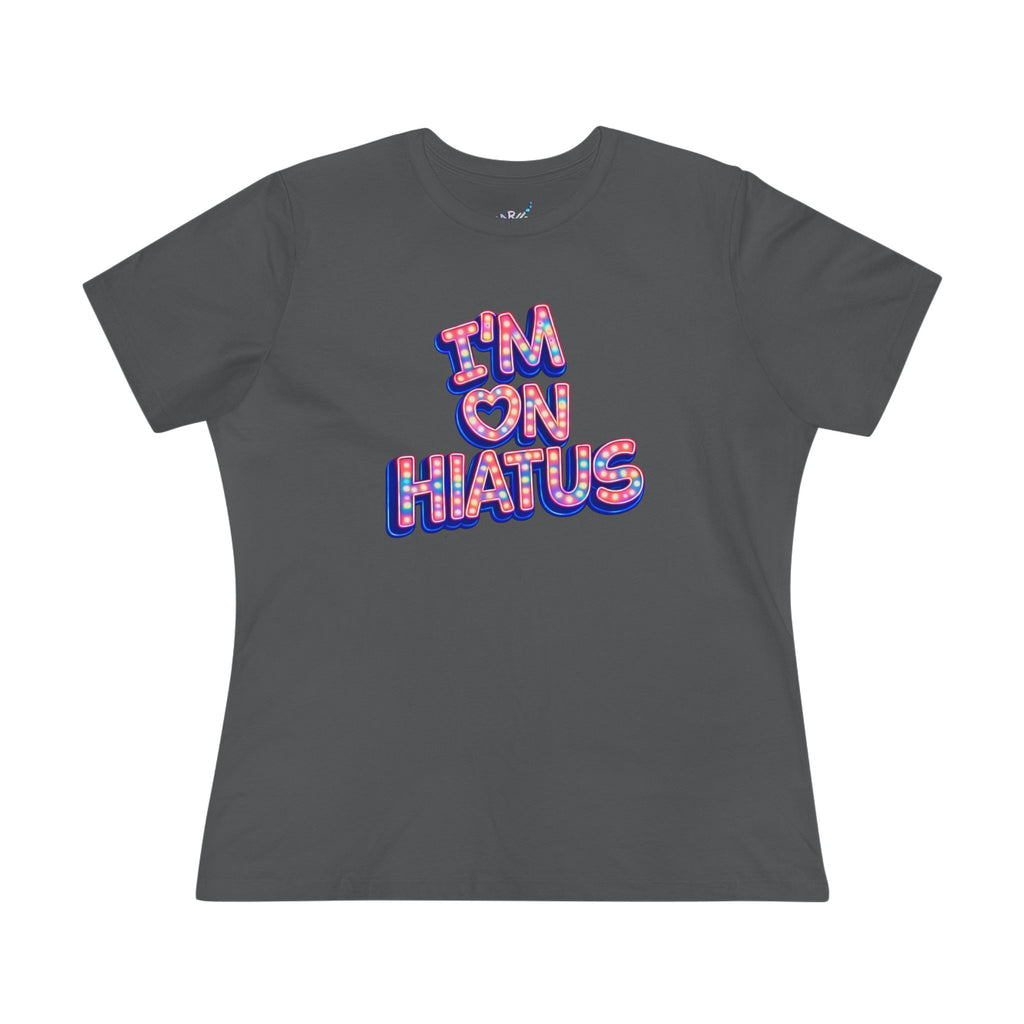 A dark gray short-sleeve t-shirt with a graphic text print reading 'I'M ON HIATUS' in a pink, red, and blue patterned bubble font, displayed on a clean white background.